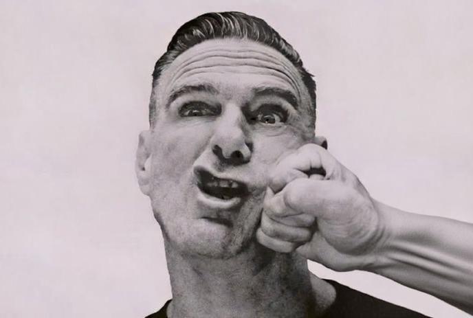 Bryan Adams being punched in the face by a clenched fist.