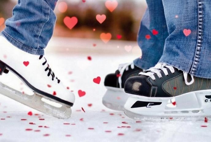 Two people ice skating, wearing casual jeans and different skates, surrounded by floating red hearts.