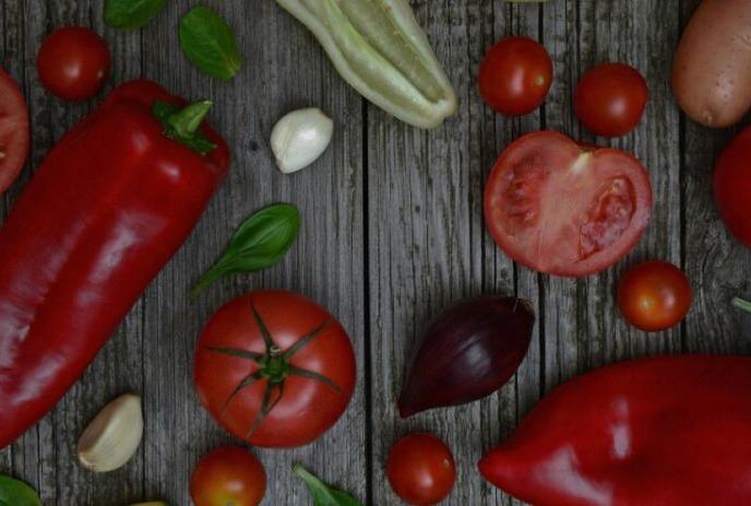 A rustic wooden table displays fresh vegetables, evoking a fresh, garden feel.