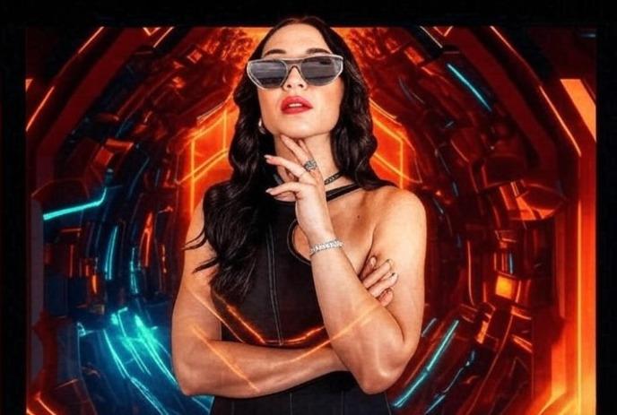 MARTA wearing sunglasses posing for the camera in front of a red/blue background.