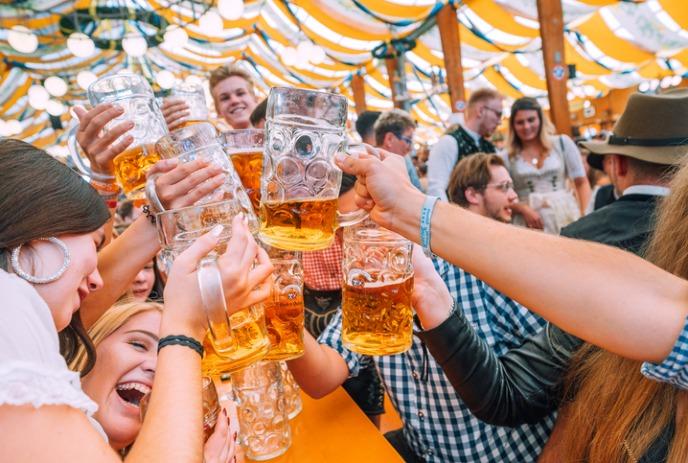 People cheersing beers at an Oktoberfest event.