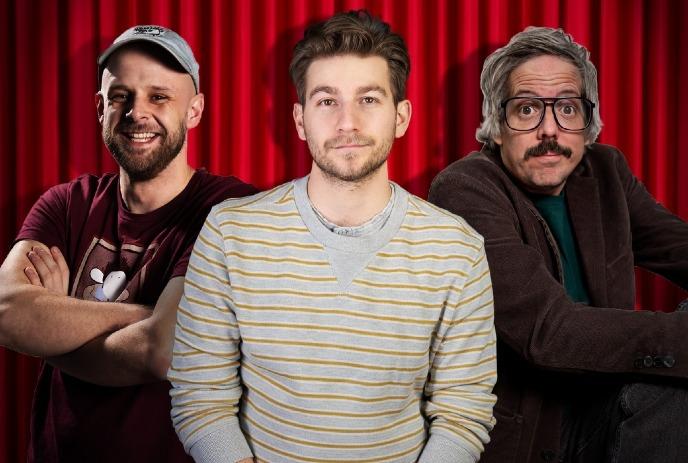 Three men stand confidently in front of red curtains.