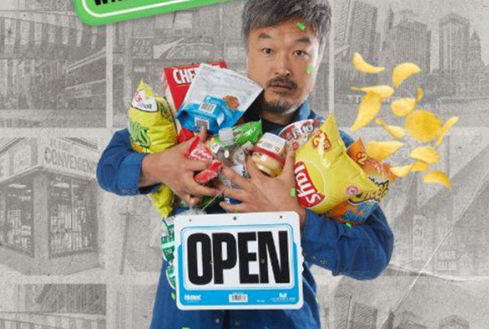 Man with his arms full of groceries including a bag of chips going all over the place.