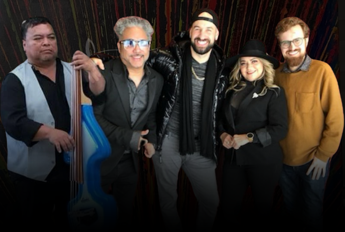 Five artists stand together with bright blue bass before dark backdrop marked by vivid vertical streaks.