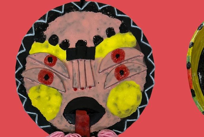 A colorful abstract mask with bold patterns and bright accents against a red background.