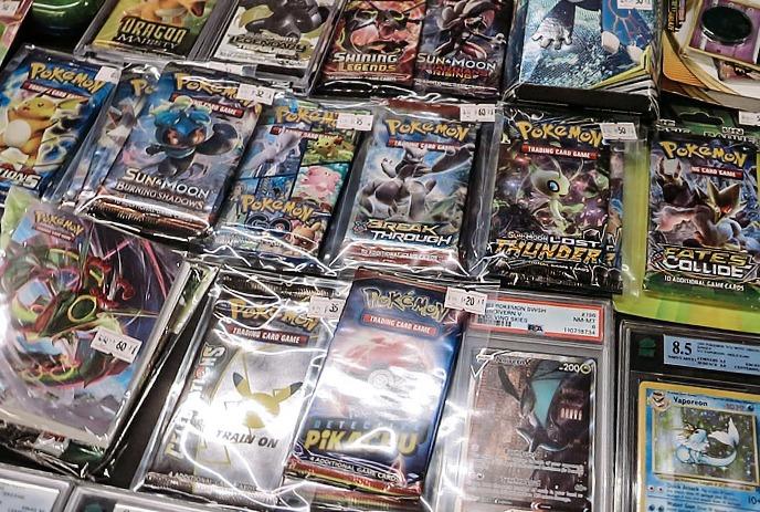 Table filled with colorful retro signs comics cards and small collectibles arranged together at a market display.
