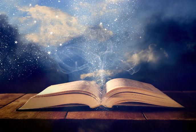 An open book emits sparkling stars and mist against a dreamy night sky.