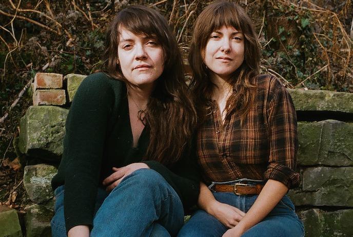 Three vintage-style photos feature women with long hair and contemplative expressions. Ornate floral designs decorate the top.
