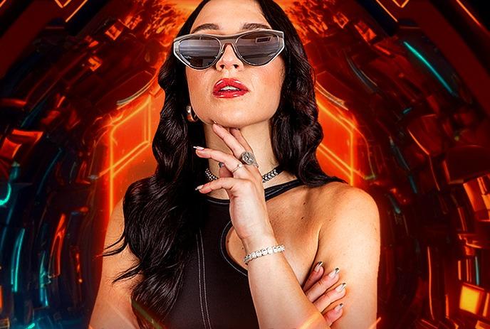 MARTA wearing sunglasses posing for the camera in front of a red/blue background.