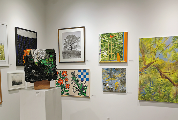 Art gallery corner with various artworks: sculpture, tree photo, ladder painting, floral design, and landscapes.