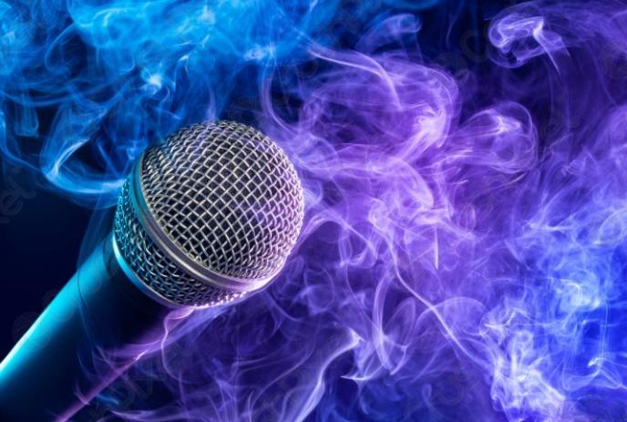 A microphone is surrounded by colorful purple and blue smoke on a dark background.