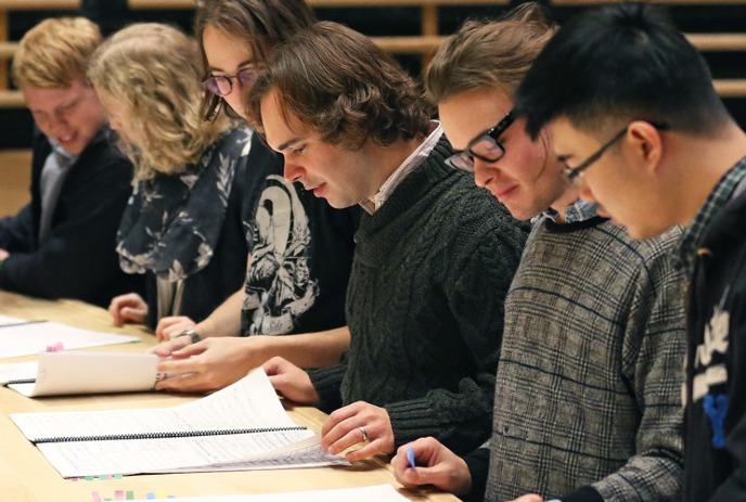 Group of students looking at musical notes.