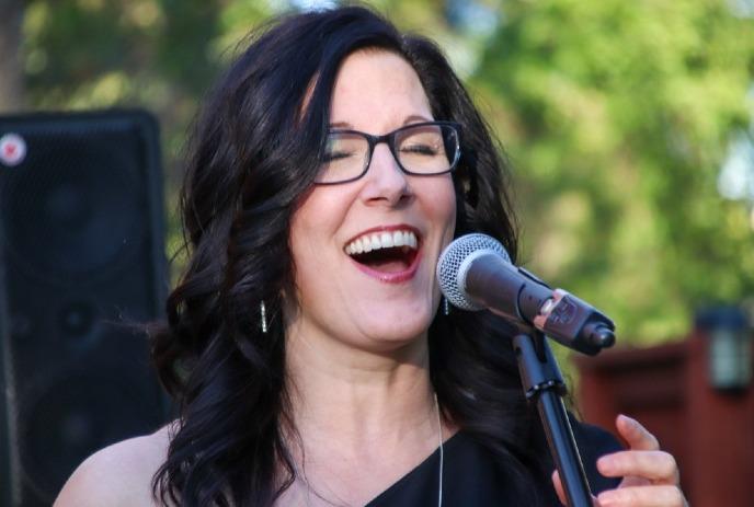 Cara Lianne McLeod singing with microphone.