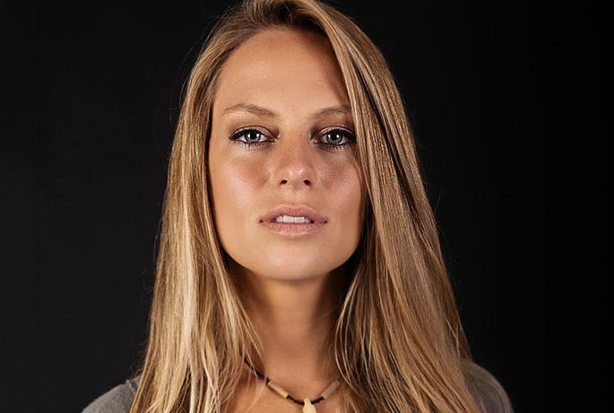 Nora en pure before teal background with leaf patterns.