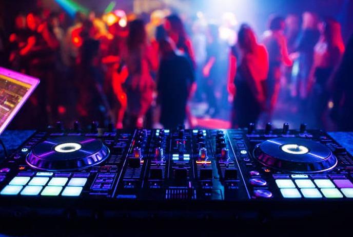 A smoky, lit up concert stage with a microphone in the centre of it.