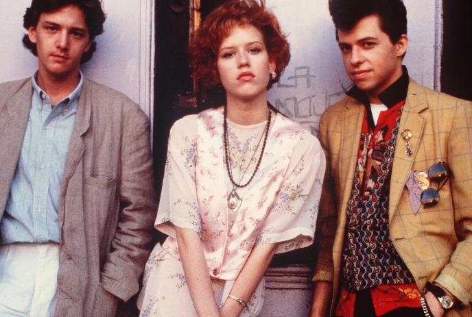 Two men and a women posing, one with blazer, floral dress, and yellow plaid jacket pop with flair.