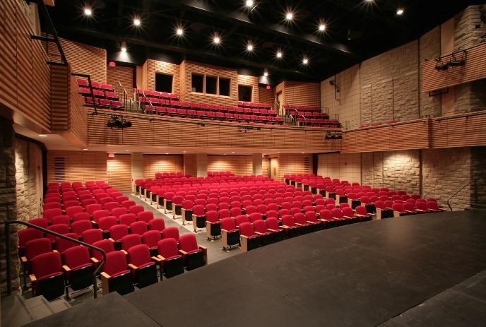 A view of red seats in the auditorium of the Paul Davenport Theatre as seen from the stage.