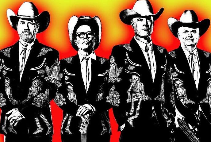 Four musicians in skeleton suits and cowboy hats standing before colorful panels holding instruments.
