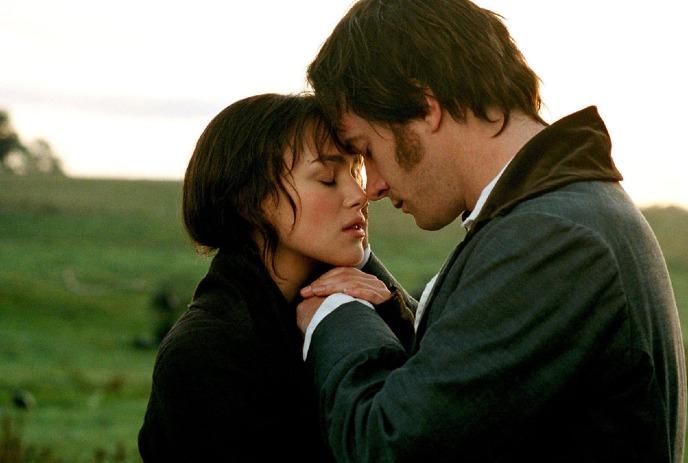 Two characters stand close together holding hands.