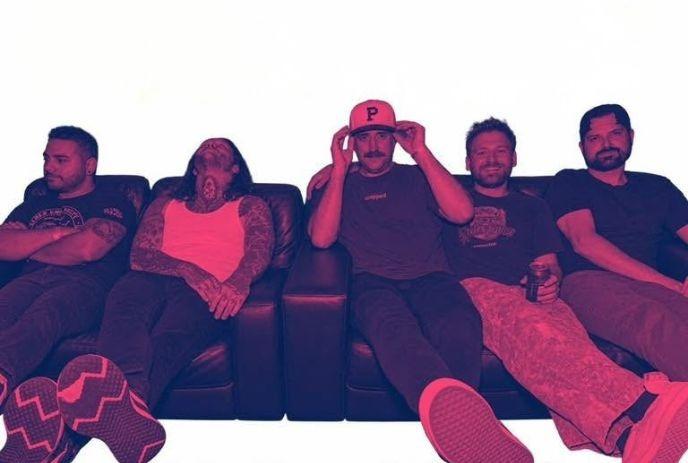 Five people sit on couch in tinted red purple scene with casual poses and modern artistic vibe.