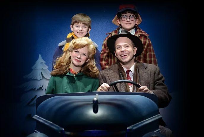 A family of four riding in car two adults in front with wheel and two smiling children behind in winter scene