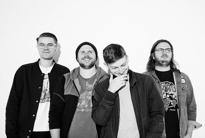 A black and white photo of the 4 band members of Pup, standing against a white background, posing for the camera.