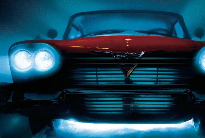 A classic car glows through drifting mist as its bright headlights cut sharply across the frame.