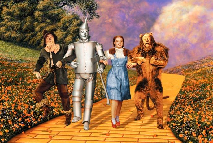 Scarecrow, Tin Man, Dorothy and the Cowardly Lion walk together along the Yellow Brick Road.