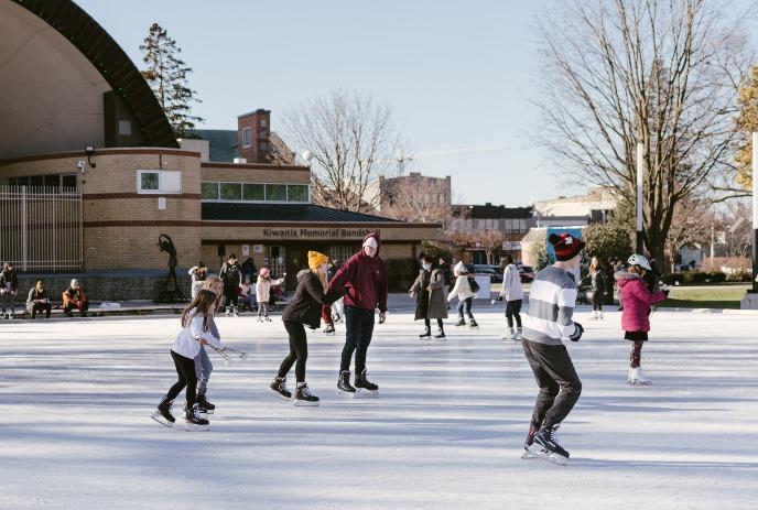 People enjoy ice skating on a sunny day at Victoria Park.