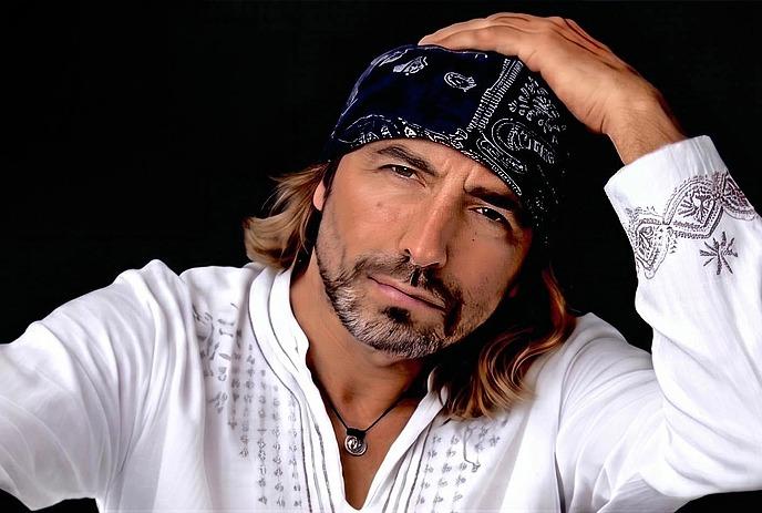 Remigio wearing a white top with a cap on his head, posing for a photo