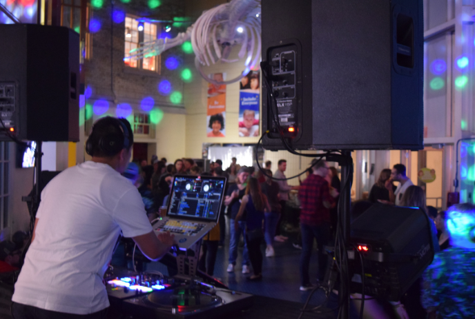 A DJ booth looking out onto the floor of a previous Retro Recess event, filled with people and lights.