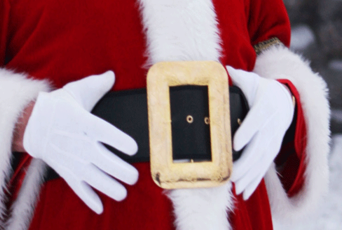 Santa's hands in white gloves around his black belt with gold buckle.