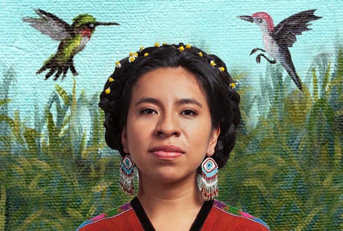 Sara Curruchich with braided hair. flowers earrings and red patterned garment before painted foliage sky and flying birds