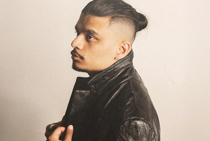 Artist in side profile wears black leather jacket, under an off-white background.
