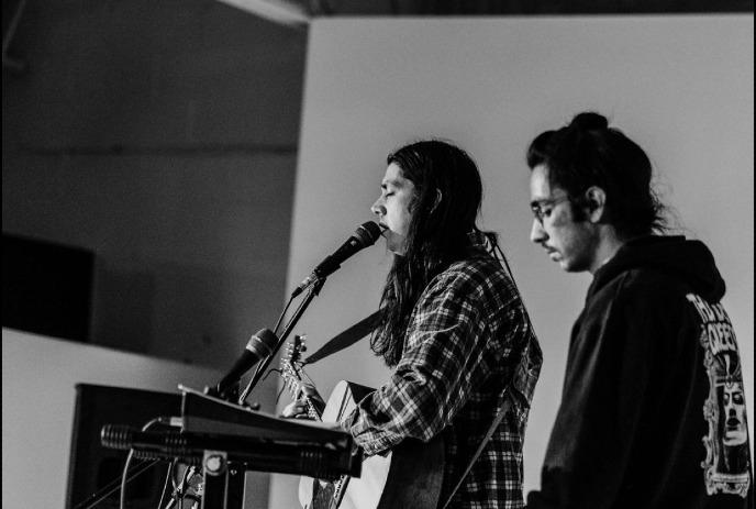 Shawn and Derek Durant stands nearby in black and white indoor music setup scene.