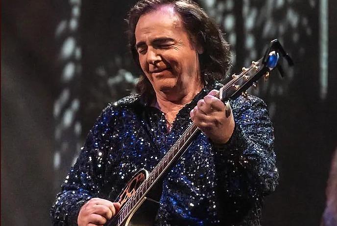 Will Chalmers performing on stage as Neil Diamond, wearing a glittering blue suit.
