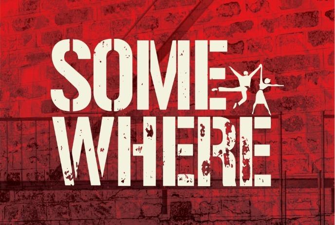 A bold white “SOMEWHERE” title painted on a red brick wall, with two dancer silhouettes inside the letter E.