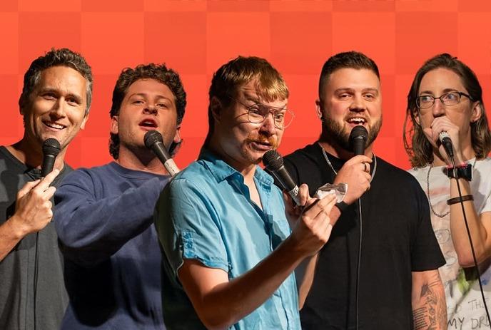 Five performers stand with microphones against an orange checkered backdrop, at a performance or event.