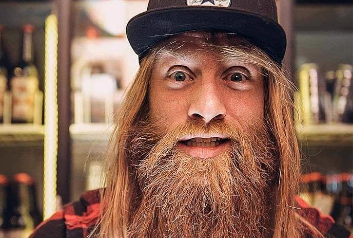 A face portrait of Jason Allen with a flowing beard and cap, staring at the camera, giving a fun, quirky expression.
