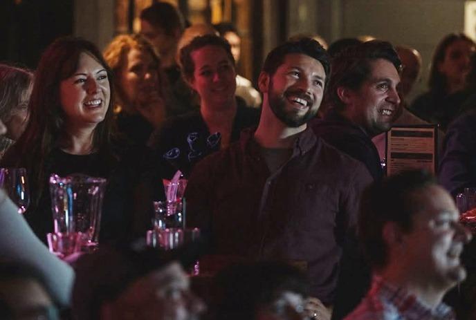 A group of people sitting around a table laugh together.