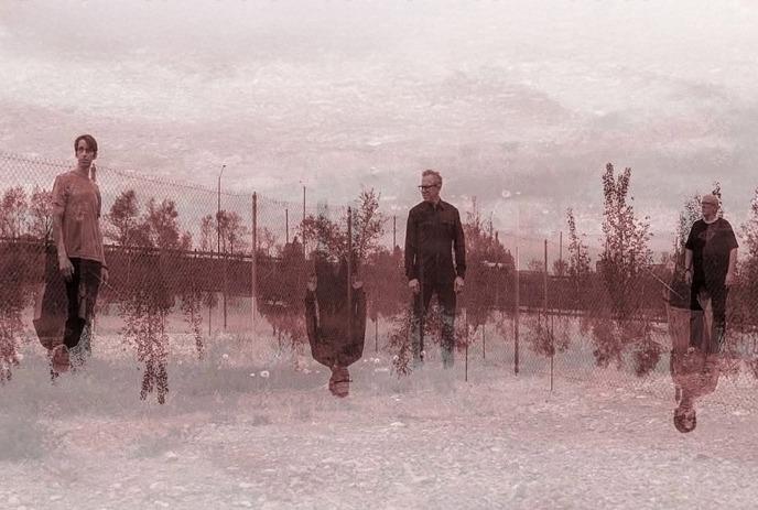 Three people stand on a gravel path, mirrored below in sepia tones, evoking reflection.