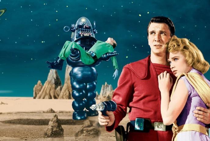 Futuristic robot carries person while two others stand armed on rocky alien landscape under starry sky.