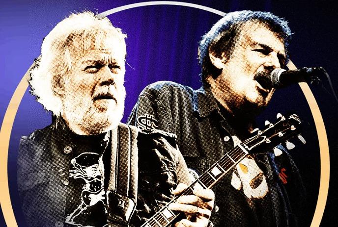 Burton Cummings and Randy Bachman on a stage with purple lighting and a golden circular frame overlay.