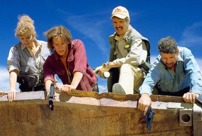 Four people looking down over a bridge with their weapons drawn.