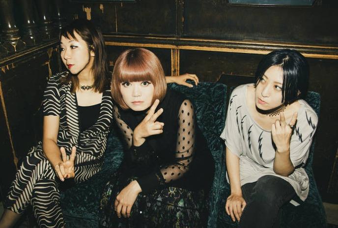 The three band members of TsuShiMaMiRe sitting on a couch, posing for the camera.
