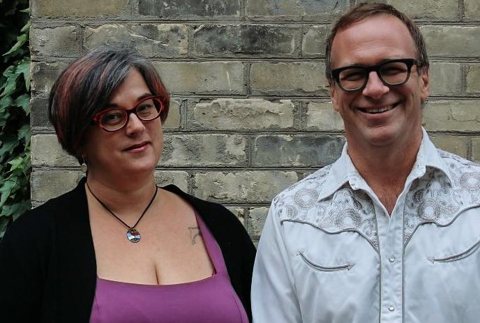 Amanda Lynn Stubley in red glasses and purple top with a black cardigan stands next to Martin Horak in glasses and a white shirt.