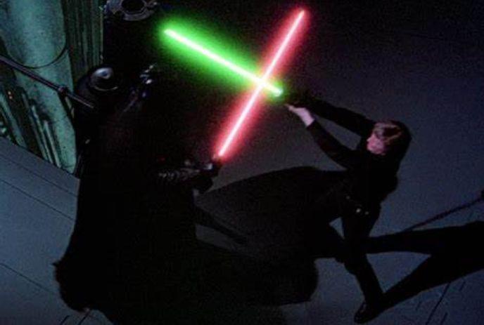 Lightsaber duel between two characters, one with a green blade and one with a red blade, in a dark setting.
