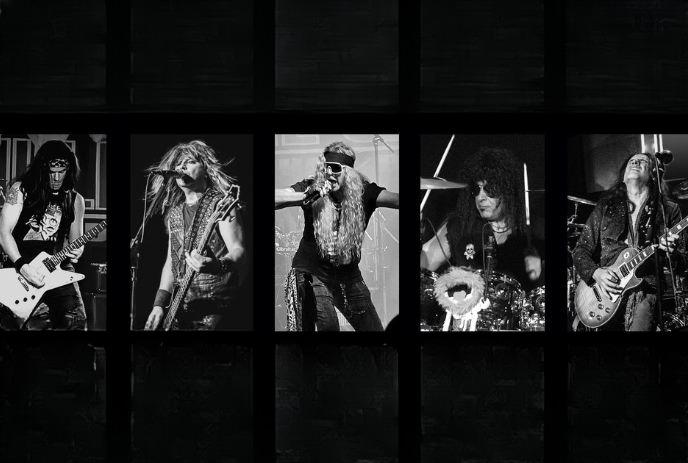 A black & white image of a rock band performing live with guitarists, drummer & vocalist on stage.