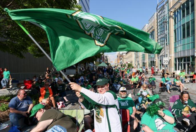 Group of people wearing London Knights merch at Dundas Place cheering and enjoying a game.
