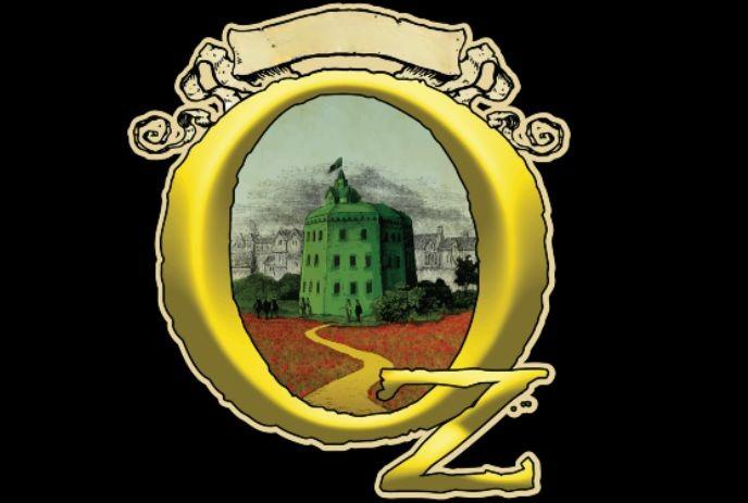 Golden “O” encircles green building, yellow brick path leads inward, with a “Z” resting bottom-right.